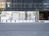 the exterior of an industrial building with concrete parking spaces and metal barriers on both sides