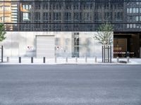 the exterior of an industrial building with concrete parking spaces and metal barriers on both sides