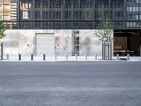 the exterior of an industrial building with concrete parking spaces and metal barriers on both sides