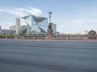 there is a very tall building by the road with glass windows in it on this bridge