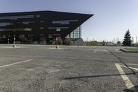 a black building with an orange sign sitting on top of a parking lot with lots of trees in front