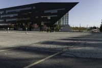 a black building with an orange sign sitting on top of a parking lot with lots of trees in front