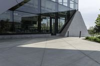 a large building with a window on the side of it on a concrete sidewalk in front of an empty grassy area