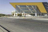 the large glass building has a yellow covering on the front of it's walls