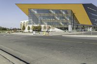 the large glass building has a yellow covering on the front of it's walls