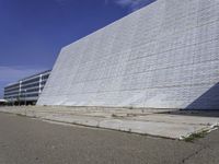 a white building with a roof and windows sits in a quiet area outside the buildings