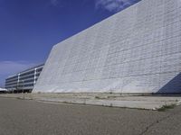 a white building with a roof and windows sits in a quiet area outside the buildings