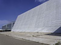 a white building with a roof and windows sits in a quiet area outside the buildings