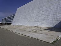 a white building with a roof and windows sits in a quiet area outside the buildings