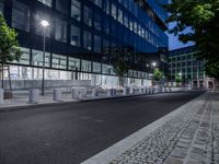 benches and street lighting in front of a building at night in an urban setting -