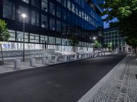 benches and street lighting in front of a building at night in an urban setting -