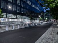 benches and street lighting in front of a building at night in an urban setting -