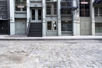a fire hydrant sitting outside of a glass building with stairs next to it and a parking meter in front