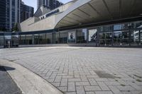 a person sitting at the bench in front of a mall that is empty of people