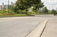 a fire hydrant in a deserted street with trees and buildings in the background '