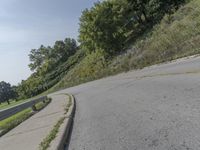 a fire hydrant sitting on the side of a road near grass and trees -