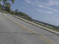 a fire hydrant sitting on the side of a road near grass and trees -