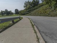 a fire hydrant sitting on the side of a road near grass and trees -