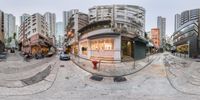 an image from a fisheye lens looking at a city street with multiple buildings and cars