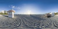 a beach with boats parked in the sand and sun shining on the horizon and water