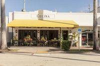 a sidewalk and sidewalk area in front of a restaurant with yellow awnings on both sides