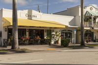 a sidewalk and sidewalk area in front of a restaurant with yellow awnings on both sides