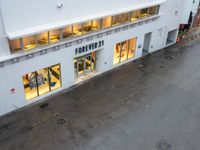 an overhead view of a store with the windows open at night with rain pouring down