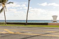 the sidewalk is on both sides of the beach, leading to a lifeguard station on top