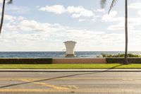 a building that has a lifeguard stand near the water on a beach side walkway