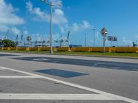 the street is empty during the day, and some signs are painted on it and there are no cars