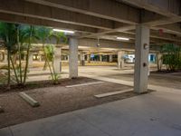 a concrete parking garage with concrete planters and gravel on the ground inside it is shown in image