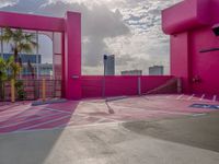 a view of the sky in a bright pink building, from a parking lot with a large parking space