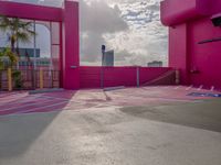 a view of the sky in a bright pink building, from a parking lot with a large parking space