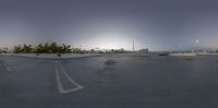 an empty parking lot in the early hours time with buildings in the distance behind it