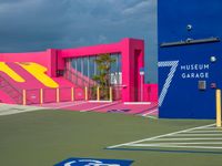 a pink and blue museum garage on a tennis court next to stairs with a red box at one end