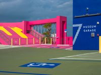 a pink and blue museum garage on a tennis court next to stairs with a red box at one end