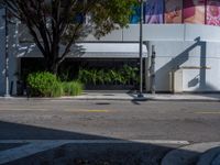 a parking meter sitting next to a road under trees and a building with a sign