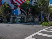 a stop sign and a pedestrian crossing in front of a building with american flag decorations