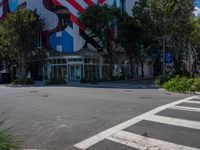 a stop sign and a pedestrian crossing in front of a building with american flag decorations