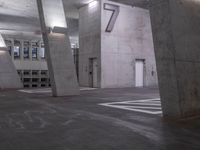 the floor at a parking garage has painted numbers in white writing on it and is illuminated by overhead lights