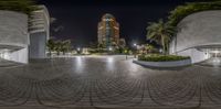 the view of an empty circle in a public space with skyscrapers in the distance