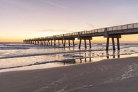 the long beach has some people walking near it at sunset over the water and on the shore