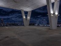 a empty parking garage filled with white lights under some dark clouds at night - time