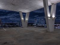 a empty parking garage filled with white lights under some dark clouds at night - time