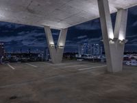 a empty parking garage filled with white lights under some dark clouds at night - time