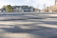 a empty street and an intersection with cars on the road near it in front of a home