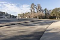 street and road sign with houses in background near water reservoir and fenced sidewalk on sidewalk