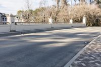 there is an empty paved roadway outside the houses to the street from the curb and sidewalk