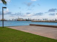 a view of a large body of water near the shore line of a city with tall buildings in the background