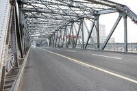 the bridge is spanning two lanes on the left side with trucks and trucks behind it